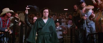 Movie still from “Man on the Moon” (1999), directed by Milos Forman – A man in a robe standing in front of a crowd; Medium shot, Low angle