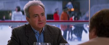 Movie still from “Man on the Moon” (1999), directed by Milos Forman – An older man sitting at a table with wine glasses in front of him; Close Up shot, Over the shoulder angle