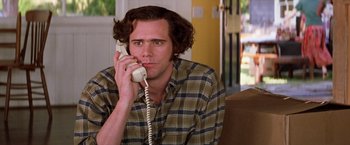 Movie still from “Man on the Moon” (1999), directed by Milos Forman – A man sitting on a couch talking on a phone; Close Up shot, Low angle