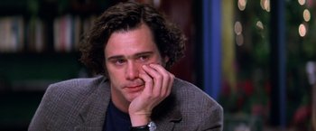 Movie still from “Man on the Moon” (1999), directed by Milos Forman – A person sitting with his hand to his face; Close Up shot, Over the shoulder angle