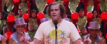 Movie still from “Man on the Moon” (1999), directed by Milos Forman – A man in a white shirt is speaking into a microphone; Medium shot, Over the shoulder angle