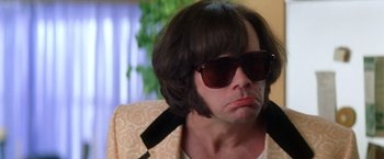 Movie still from “Man on the Moon” (1999), directed by Milos Forman – A man wearing sunglasses and a wig; Close Up shot, Low angle
