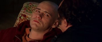 Movie still from “Man on the Moon” (1999), directed by Milos Forman – A man with a bald head is looking at another man; Close Up shot, Over the shoulder angle