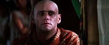Movie still from “Man on the Moon” (1999), directed by Milos Forman – A man with a bald head looking into the camera; Close Up shot, Low angle