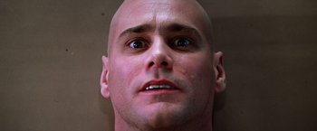Movie still from “Man on the Moon” (1999), directed by Milos Forman – A man with a bald head looking up at the camera; Close Up shot, Low angle