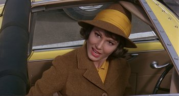 Movie still from “Man's Favorite Sport?” (1964), directed by Howard Hawks – A woman wearing a brown coat and a yellow hat; Close Up shot, High angle