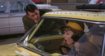 Movie still from “Man's Favorite Sport?” (1964), directed by Howard Hawks – A man and a woman sitting in a yellow car; Medium shot, Over the shoulder angle