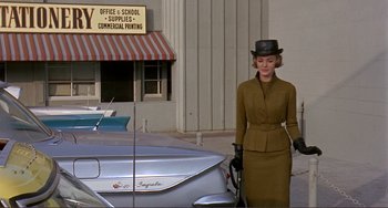 Movie still from “Man's Favorite Sport?” (1964), directed by Howard Hawks – A woman in a hat and gloves standing next to a boat; Wide shot, Low angle