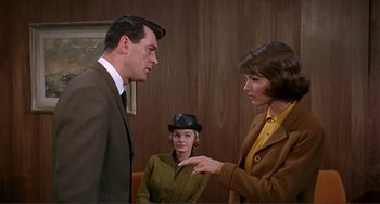 Movie still from “Man's Favorite Sport?” (1964), directed by Howard Hawks – A man and a woman are talking to another woman; Medium shot, Over the shoulder angle