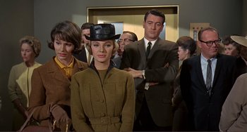 Movie still from “Man's Favorite Sport?” (1964), directed by Howard Hawks – A group of people standing around a woman wearing a hat; Medium shot, Over the shoulder angle
