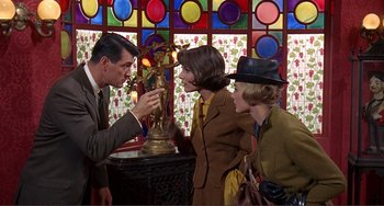 Movie still from “Man's Favorite Sport?” (1964), directed by Howard Hawks – Two women and a man are looking at a statue; Medium shot, Over the shoulder angle