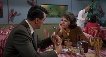Movie still from “Man's Favorite Sport?” (1964), directed by Howard Hawks – A man and a woman sitting at a table; Medium shot, Over the shoulder angle