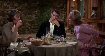 Movie still from “Man's Favorite Sport?” (1964), directed by Howard Hawks – A group of people sitting at a table with food; Medium shot, Over the shoulder angle