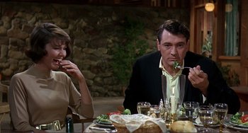 Movie still from “Man's Favorite Sport?” (1964), directed by Howard Hawks – A man and a woman sitting at a dinner table; Medium shot, Over the shoulder angle