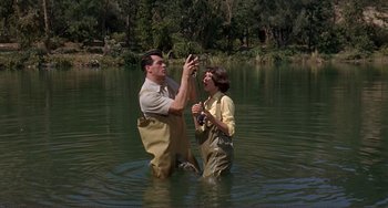 Movie still from “Man's Favorite Sport?” (1964), directed by Howard Hawks – A man and a woman in the water holding hands; Medium shot, Low angle