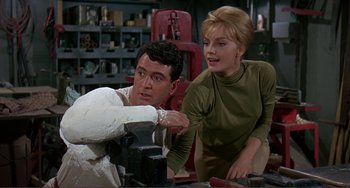 Movie still from “Man's Favorite Sport?” (1964), directed by Howard Hawks – A man and a woman working in a workshop; Medium shot, Low angle