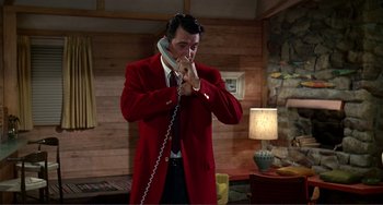 Movie still from “Man's Favorite Sport?” (1964), directed by Howard Hawks – A man in a red jacket is on the phone; Medium shot, High angle