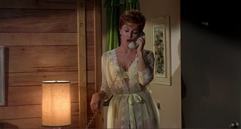 Movie still from “Man's Favorite Sport?” (1964), directed by Howard Hawks – A woman talking on a phone while wearing a robe; Medium shot, High angle