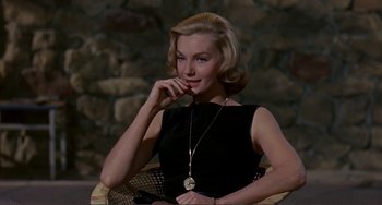 Movie still from “Man's Favorite Sport?” (1964), directed by Howard Hawks – A woman sitting in a chair wearing a necklace; Medium shot, High angle