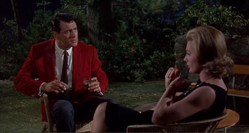 Movie still from “Man's Favorite Sport?” (1964), directed by Howard Hawks – A man and a woman sitting on a chair talking to each other; Medium shot, Over the shoulder angle