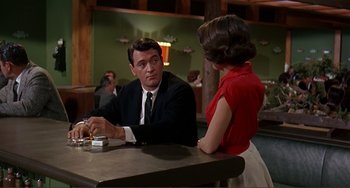 Movie still from “Man's Favorite Sport?” (1964), directed by Howard Hawks – A man and a woman sitting at a table in a restaurant; Medium shot, Over the shoulder angle