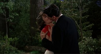 Movie still from “Man's Favorite Sport?” (1964), directed by Howard Hawks – A man and a woman kissing in a forest; Medium shot, High angle
