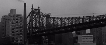 Movie still from “Manhattan” (1979), directed by Woody Allen – A black - and - white photo of a bridge in a city; Extreme Wide shot, Low angle