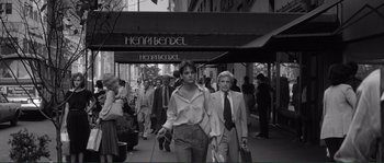 Movie still from “Manhattan” (1979), directed by Woody Allen – A black - and - white photo of people walking down a street; Wide shot, Over the shoulder angle