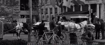 Movie still from “Manhattan” (1979), directed by Woody Allen – A group of people riding bikes down a street; Wide shot, High angle