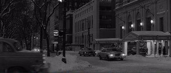 Movie still from “Manhattan” (1979), directed by Woody Allen – A black - and - white photo of a city street with snow on the ground; Extreme Wide shot, High angle