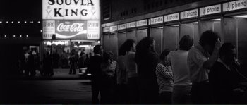 Movie still from “Manhattan” (1979), directed by Woody Allen – A group of people standing in a line in front of a building; Wide shot, High angle