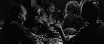 Movie still from “Manhattan” (1979), directed by Woody Allen – A black and white photo of people sitting at a table; Medium shot, Over the shoulder angle