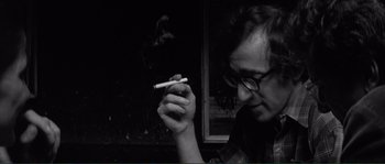 Movie still from “Manhattan” (1979), directed by Woody Allen – A man is smoking a cigarette in a dark room; Close Up shot, Over the shoulder angle