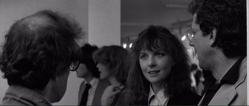 Movie still from “Manhattan” (1979), directed by Woody Allen – Black and white photograph of a woman in front of a group of people; Close Up shot, Over the shoulder angle