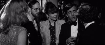 Movie still from “Manhattan” (1979), directed by Woody Allen – A group of people standing next to each other in a room; Medium shot, Over the shoulder angle