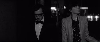 Movie still from “Manhattan” (1979), directed by Woody Allen – A man in a suit and tie standing next to another man in a suit and tie; Close Up shot, Over the shoulder angle