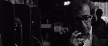 Movie still from “Manhattan” (1979), directed by Woody Allen – A man sitting at a table talking on a cell phone; Close Up shot, Over the shoulder angle