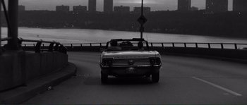 Movie still from “Manhattan” (1979), directed by Woody Allen – A black - and - white photo of a car on the road; Wide shot, High angle
