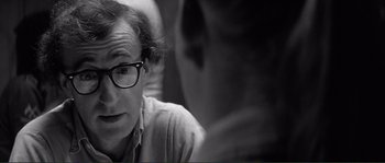 Movie still from “Manhattan” (1979), directed by Woody Allen – A black and white photo of a man wearing glasses; Close Up shot, Over the shoulder angle