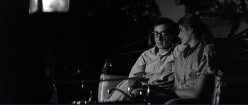 Movie still from “Manhattan” (1979), directed by Woody Allen – A black and white photo of a man sitting in a chair; Medium shot, High angle
