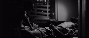 Movie still from “Manhattan” (1979), directed by Woody Allen – A person laying in a bed next to a window; Medium shot, Over the shoulder angle