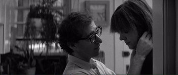 Movie still from “Manhattan” (1979), directed by Woody Allen – A man wearing glasses and a tie talking to another man; Close Up shot, Over the shoulder angle