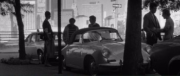 Movie still from “Manhattan” (1979), directed by Woody Allen – Two people standing next to a parked car; Wide shot, High angle