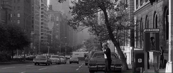 Movie still from “Manhattan” (1979), directed by Woody Allen – An old black and white photo of a man on the side of the road; Wide shot, High angle