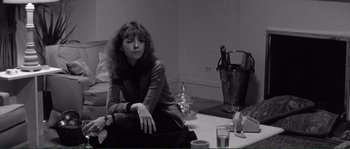 Movie still from “Manhattan” (1979), directed by Woody Allen – A black and white photo of a woman sitting at a table; Medium shot, High angle