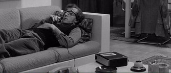 Movie still from “Manhattan” (1979), directed by Woody Allen – An older man laying on a couch playing a video game; Medium shot, High angle