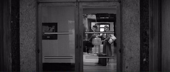 Movie still from “Manhattan” (1979), directed by Woody Allen – A man and a woman standing in front of a door; Wide shot, Over the shoulder angle