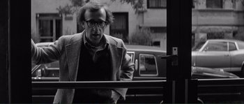 Movie still from “Manhattan” (1979), directed by Woody Allen – A black and white photo of a man looking out of a window; Medium shot, Over the shoulder angle