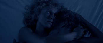 Movie still from “Manhunter” (1986), directed by Michael Mann – A woman laying in bed with her head on her shoulder; Close Up shot, Overhead angle
