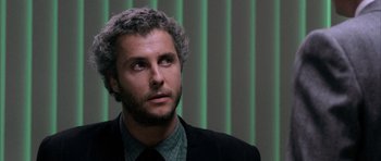 Movie still from “Manhunter” (1986), directed by Michael Mann – A person wearing a suit and tie; Close Up shot, Over the shoulder angle